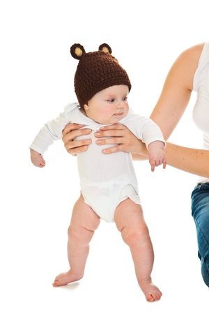 Cute infant baby girl learning to stand isolated on whiteの写真素材