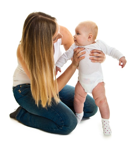 Cute infant baby girl learning to stand isolated on whiteの写真素材