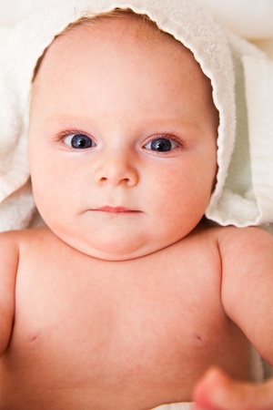 Cute infant girl happy in white towelの写真素材