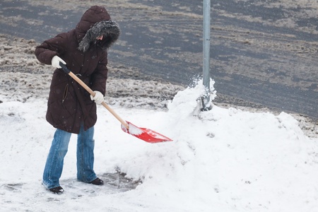 Woman shoveling snowの写真素材