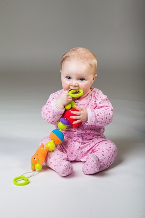 Infant girl playing in room on wooden floorの写真素材