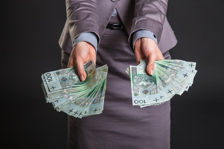 Woman with polish zloty money on dark gray backgroundの写真素材
