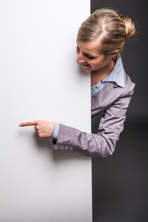 Woman behind white banner on dark gray backgroundの写真素材