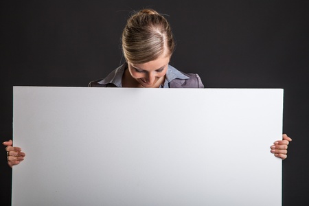 Woman behind white banner on dark gray backgroundの写真素材