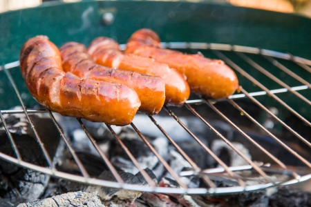 Tasty sausages burning on hot barbequeの写真素材