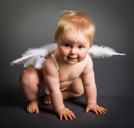 Infant baby with angel wings on neutral backgroundの写真素材
