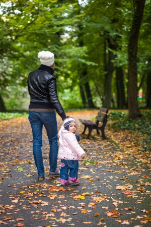 Infant baby girl in golden autumn parkの写真素材