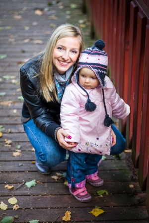 Infant baby girl in golden autumn parkの写真素材