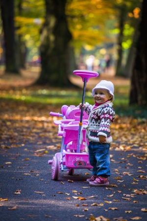 Infant baby girl in golden autumn parkの写真素材