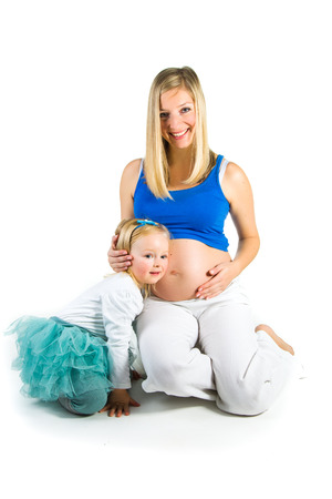 Pregnant woman with 2 zo daughter on whiteの写真素材