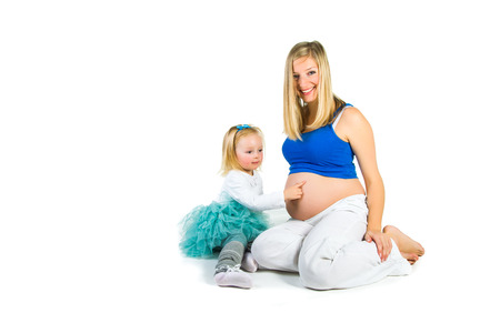 Pregnant woman with 2 zo daughter on whiteの写真素材