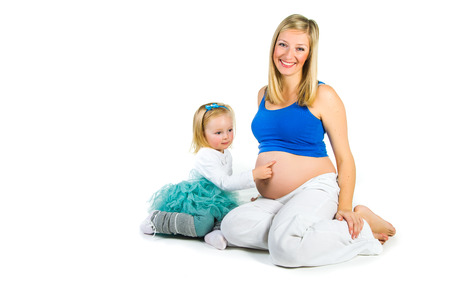 Pregnant woman with 2 zo daughter on whiteの写真素材