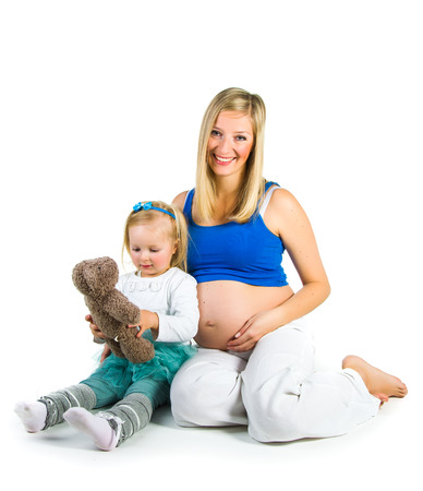 Pregnant woman with 2 zo daughter on whiteの写真素材