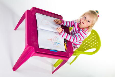 Child drawing with crayons isolated on whiteの写真素材