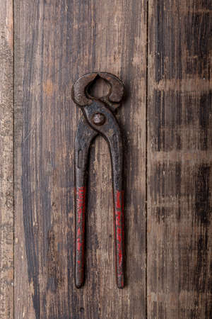 old pliers hand tool isolated on wood top viewのeditorial素材