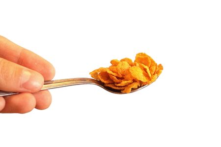 Tea spoon of corn flakes on white isolated backgroundの写真素材