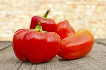 Red peppers on old wooden table の写真素材