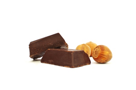 Broken chocolate and hazelnut on white background の写真素材