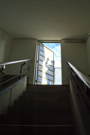 Staircase leading to shadows on door, business metaphorの写真素材