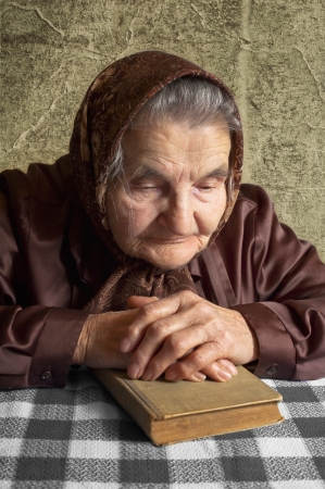 Elderly woman holds bible and pray の写真素材