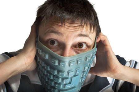 Scared person holding rubber keyboard on face 