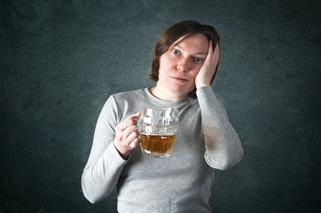 Portrait of an adult woman drinking beer, sad face - depression concept  の写真素材
