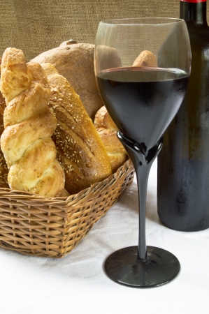 Still life assortment of bread with a glass of red wine and bottle  Selective focus on glass of red wine の写真素材