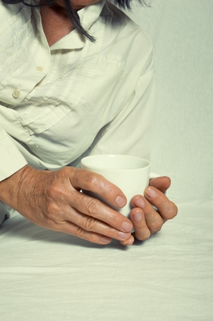 Hands of a adult woman holding a cup の写真素材