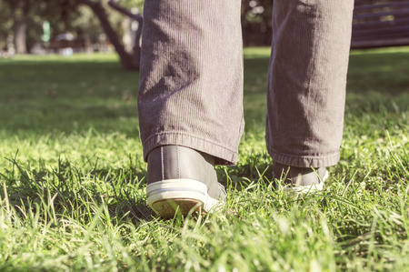 Person walking on green grass. Selective focus.の写真素材