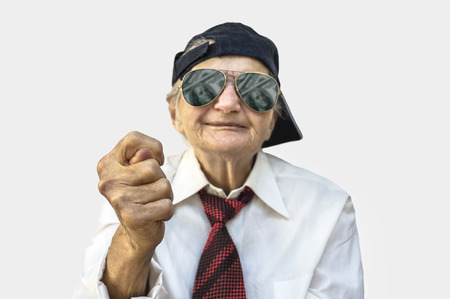 Elderly woman showing fig sign. Selective focus on hand