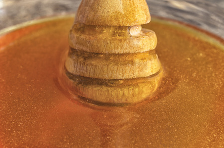 Bee honey with wooden dipper. Selective focusの写真素材
