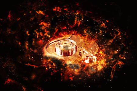 Computer hard disk on fire, burning in flames. Data loss concept, computer crash.