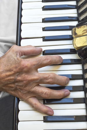 Details of a hand on an old accordion while playing. Selective focus.の写真素材