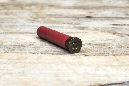 Close up of 12mm bullet on wooden table. Selective focus.の写真素材