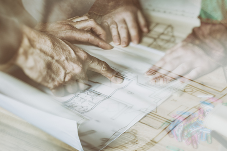 Hands of engineer working on architectural project. Construction concept. Double exposure of...