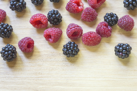 Top view of summer fresh berries on wooden table. Healthy organic ripe raspberries and blackberries fruit.の写真素材