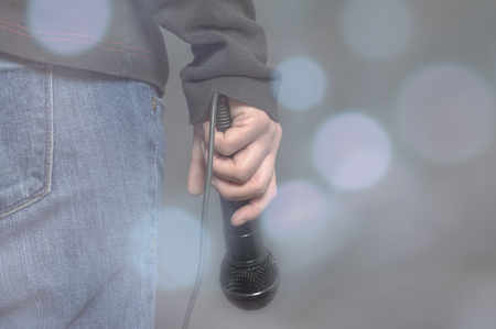 Hand with microphone on blurred background. Concept as music instrument in studio room and meeting hallの写真素材
