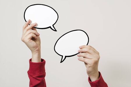 Hand holding two blank speech bubble sign ready for message