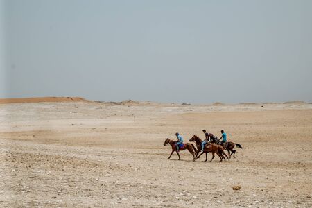 Giza, Egypt - 2018: Front view of tourists in a horse-drawn carriage with the ancient pyramids of Giza on backgroundのeditorial素材