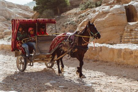 Petra, Jordan - May 2018: Horse-drawn carriage moving in the narrow canyon valley in the Ancient City.のeditorial素材