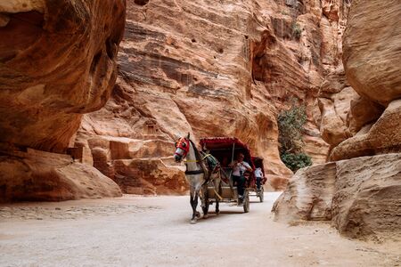 Petra, Jordan - May 2018: Horse-drawn carriage moving in the narrow canyon valley in the Ancient City.のeditorial素材