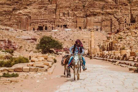 PETRA, JORDAN - May 2018:Jordanian Bedouin man rides a donkey in Petra on November 09 2007.Petra was originally the capital city of the Nabataeans, an ancient Arab civilization.のeditorial素材