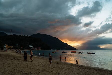 Puerto Galera of Oriental Mindoro, Philippines Nov 2016. People watching sunset. Silhouettes and figure tourists see off beautiful sunset. Dramatic orange sea sunset. Luxury tropical vacation.のeditorial素材