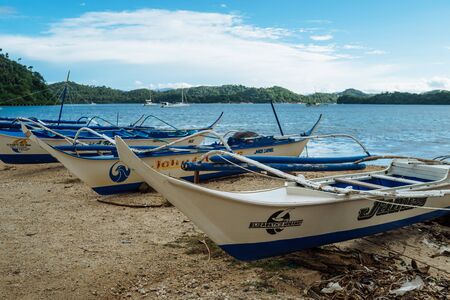 Seascape of beach with transparent sea, blue sky, palms and boats.Taken at Sabang, Puerto Galera, Mindoro island, Philippines, popular tourist and diving spot. Nov 2016.のeditorial素材