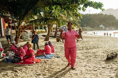 Bohol Island, Philippines- 5/11/2016 Tourists were enjoying massage service under a palm tree on the beach.Massage business was a common business on the beach in Mindoro Island.のeditorial素材