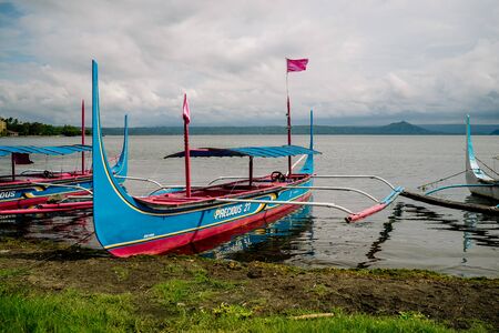 Phishing boat on a shore of beautiful Lake Taal, Philippines. Landscape of Luzon Island with volcano on the lake that changed the area geometry a few centuries ago. Dec 2018, Philippinesのeditorial素材