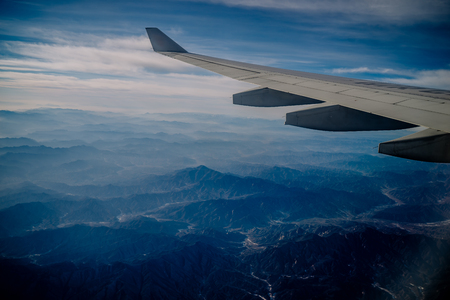 An aerial view of Chinese mountains from the airplane flying high above the ground. A look from the plane window.の写真素材
