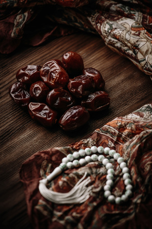 Dried dates fruit with white rosary on wooden table. Top view. The Muslim feast of the holy month of Ramadanの写真素材