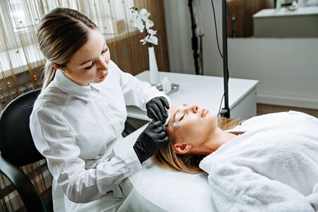 Young woman receiving plastic surgery injection on her face, closeupの写真素材