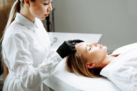Beautiful woman getting lifting injection in forehead. Close-up woman face injection. cosmetology clinicの写真素材